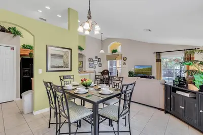 a dining room and kitchen with a table and chairs at 4 bedrooms pool home gated resort of Veranda Palms in Kissimmee