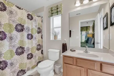 a bathroom with a toilet and a sink and a shower curtain at 4 bedrooms pool home gated resort of Veranda Palms in Kissimmee
