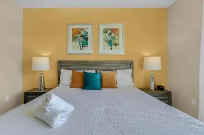 a bedroom with a large bed with two lamps at 3 bedrooms pool home with clubhouse amenities Retreat in Orlando