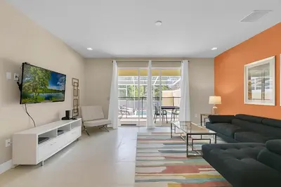 a living room with a couch and a tv at 3 bedrooms pool home with clubhouse amenities Retreat in Orlando