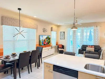 a kitchen and living room with a table and chairs at Affordable Disney pool home 3 Bed 3 bath in Orlando