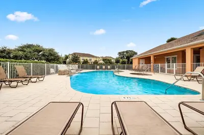 a swimming pool with benches and a fence at Affordable Disney pool home 3 Bed 3 bath in Orlando