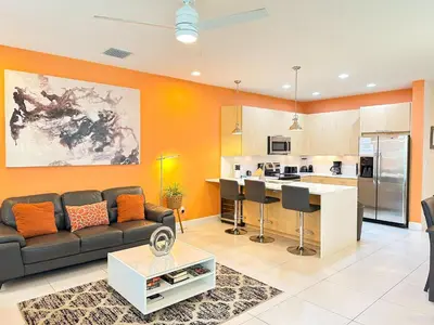 a living room with a couch and a kitchen at Affordable Disney pool home 3 Bed 3 bath in Orlando