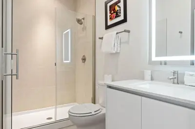 a white bathroom with a toilet and a sink at 3 bedrooms pool home Hidden Forest Resort Amenities in Orlando