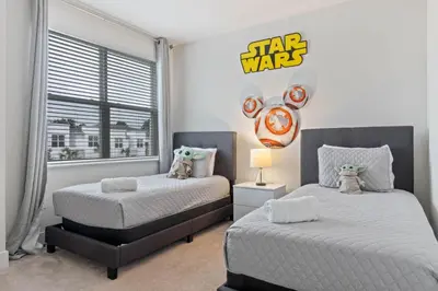 two beds in a bedroom with a star wars sign on the wall at 3 bedrooms pool home Hidden Forest Resort Amenities in Orlando