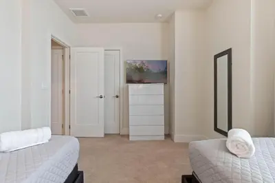 a bedroom with two beds and a tv on the wall at 3 bedrooms pool home Hidden Forest Resort Amenities in Orlando