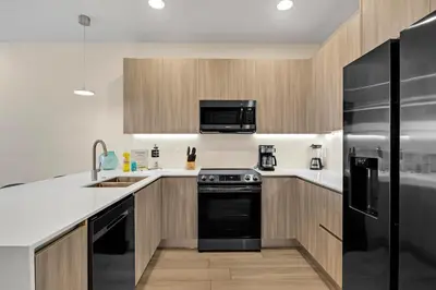 a kitchen with black appliances and wooden cabinets at 3 bedrooms pool home Hidden Forest Resort Amenities in Orlando