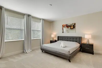a bedroom with a bed and two windows at 3 bedrooms pool home Hidden Forest in Orlando