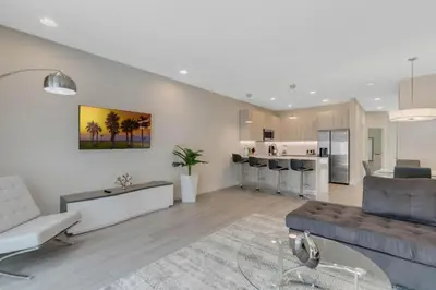 a living room with a couch and a kitchen at 3 bedrooms pool home Hidden Forest in Orlando