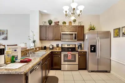 a kitchen with wooden cabinets and stainless steel appliances at WH7642SKC 3 beds pool home Gated resort in Orlando