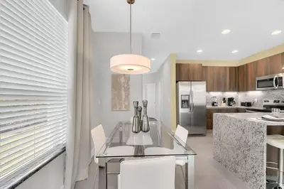 a kitchen with a glass table and a refrigerator at 3 bedrooms pool home with clubhouse amenities Retreat in Orlando