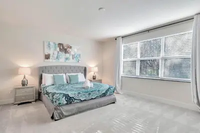 a bedroom with a bed and a large window at 3 bedrooms pool home Hidden Forest Resort Amenities in Orlando