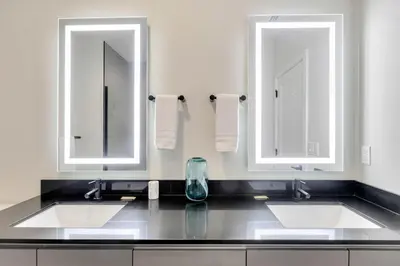 a bathroom with two sinks and two mirrors at 3 bedrooms pool home Hidden Forest Resort Amenities in Orlando