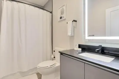 a white bathroom with a toilet and a sink at 3 bedrooms pool home Hidden Forest Resort Amenities in Orlando
