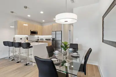 a kitchen and dining room with a glass table and black chairs at 3 bedrooms pool home Hidden Forest Resort Amenities in Orlando