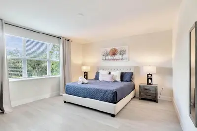 a bedroom with a bed and a large window at 4 bedrooms pool home Hidden Forest Resort Amenities in Orlando