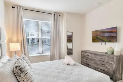 a white bedroom with a bed and a window at 4 bedrooms pool home Hidden Forest Resort Amenities in Orlando