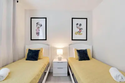 two beds in a bedroom with two pictures on the wall at 4 bedrooms pool home Hidden Forest Resort Amenities in Orlando