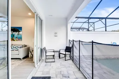 a balcony with a pool and a living room at 4 bedrooms pool home Hidden Forest Resort Amenities in Orlando