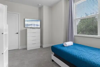 a bedroom with a bed and a tv and a window at 3 bedrooms pool home Hidden Forest Resort Amenities in Orlando