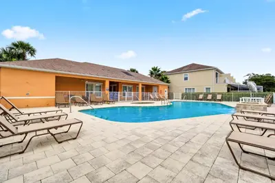a swimming pool with lounge chairs and a house at 3 bedrooms pool home Hidden Forest Resort Amenities in Orlando