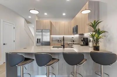 a kitchen with a island with four stools at 3 bedrooms pool home Hidden Forest Resort Amenities in Orlando