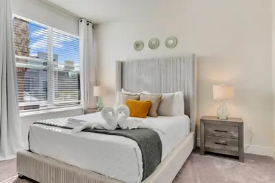 a bedroom with a bed with two towels on it at 3 bedrooms pool home Hidden Forest Resort Amenities in Orlando