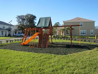 a playground with an orange slide in a yard at 3 bedrooms pool home Hidden Forest Resort Amenities in Orlando