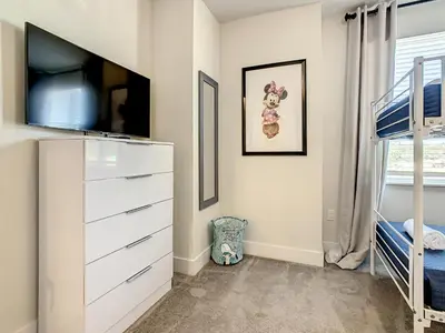 a bedroom with a dresser and a bunk bed at 3 bedrooms pool home Hidden Forest Resort Amenities in Orlando