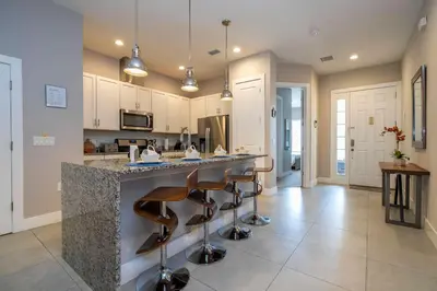a kitchen with a large island with bar stools at Gorgeous 4 Suites DREAM Villa 5 min to Disney in Orlando