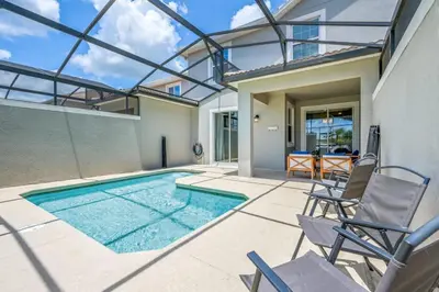 a swimming pool with chairs and a house at Magical Retreat, Spacious villa 10 min from Disney in Kissimmee