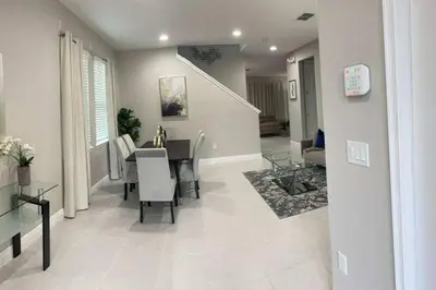 a dining room and living room with a table and chairs at Luxury 6 BR 6 Bath @Encore Resort Pool Spa Grill. in Orlando