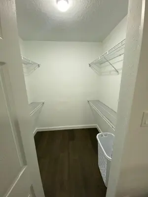 a walk in closet with white walls and wooden floors at Villa at Island Club in Kissimmee