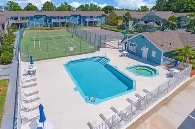 a pool and tennis court at a resort with a tennis court at Villa at Island Club in Kissimmee