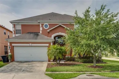 a house with a garage and a tree at S890SB - 12 guests - 6 beds in Kissimmee