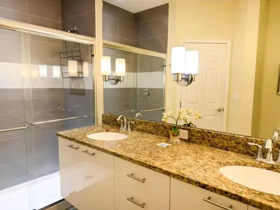 a bathroom with two sinks and a shower at Stylish 3-BR with Private Pool & Conservation View in Orlando