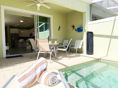 a patio with a table and chairs next to a swimming pool at Stylish 3-BR with Private Pool & Conservation View in Orlando