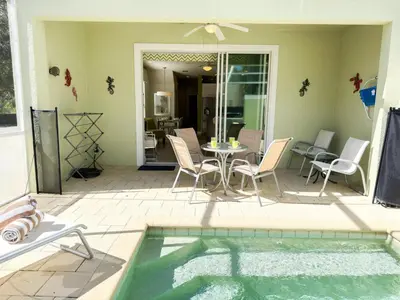 a patio with a table and chairs and a pool at Stylish 3-BR with Private Pool & Conservation View in Orlando