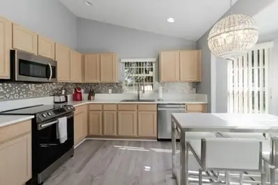 a kitchen with wooden cabinets and a table with chairs at IC8090ICB - Indian Creek Oasis in Kissimmee