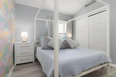 a white bedroom with a white bed with a canopy at IC8090ICB - Indian Creek Oasis in Kissimmee