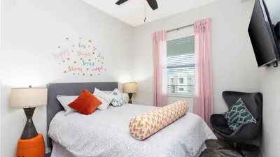 a bedroom with a bed and a chair at Strategic Condo 2 Bd Close to Disney Storey Lake in Kissimmee
