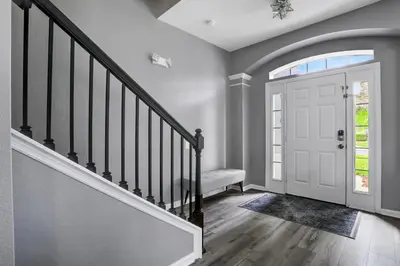 a hallway with a staircase and a white door at Themed Luxury 6BR Getaway with Resort Amenities in Orlando