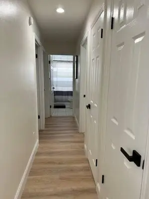 a hallway with white doors and wood floors in a house at Superhost FREE Heated Pool 9 minutes to MCO 15 minutes to Disney in Kissimmee