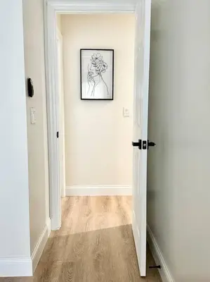 a white hallway with a picture on the wall at Superhost FREE Heated Pool 9 minutes to MCO 15 minutes to Disney in Kissimmee