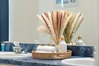 a bathroom counter with two sinks and a basket of towels at Lakeview Family Haven in Kissimmee - Pool & Scenic Views in Kissimmee