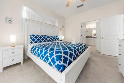 a white bedroom with a blue and white bed at Lakeview Family Haven in Kissimmee - Pool & Scenic Views in Kissimmee