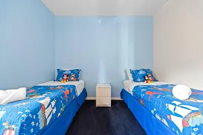 two beds in a room with blue walls at Lakeview Family Haven in Kissimmee - Pool & Scenic Views in Kissimmee