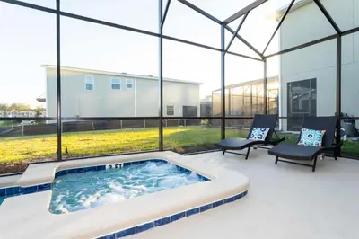 a hot tub in a patio with a large window at Spacious & Comfy Retreat Prime Location Amazing in Kissimmee
