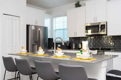 a kitchen with a large island in a kitchen with chairs at Spacious & Comfy Retreat Prime Location Amazing in Kissimmee