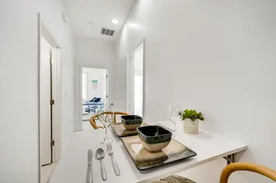 a white kitchen with a table with plants on it at 3 Mi to Lakefront Beach St Cloud Apt in Ashton